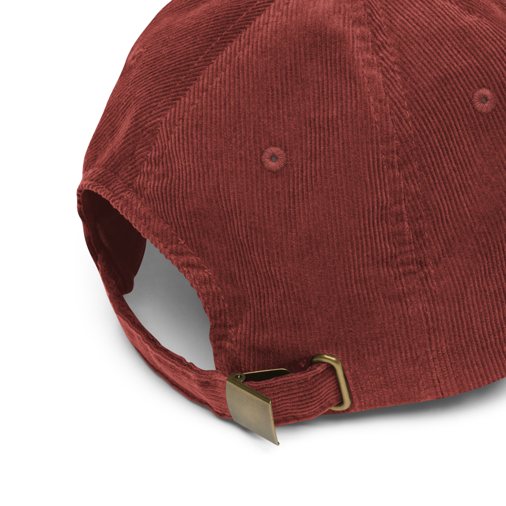 Red corduroy cap with a gold buckle on a white background