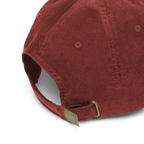 Red corduroy cap with a gold buckle on a white background
